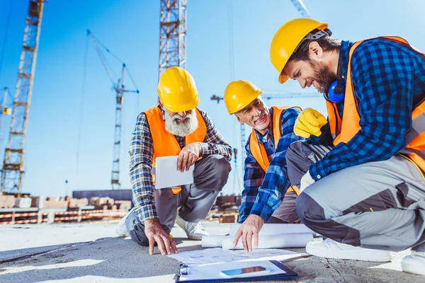 depositphotos_170349218-stock-photo-construction-workers-discussing-building-plans